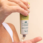Hand holding hemp hand protector tube with a beige background