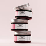 Three jars of The Body Shop Vitamin E Moisture Day Cream stacked on a light pink background