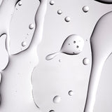 A close up shot of The Body Shop Tea Tree Oil texture on a grey background