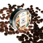 The Body Shop Shea body butter jar surrounded by shea nuts on a white background