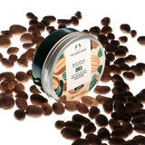 The Body Shop Shea body butter jar surrounded by shea nuts on a white background